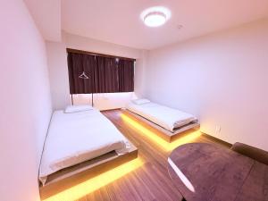 a small room with two beds and a window at Kokoro House3 in Tokyo