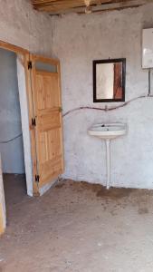 a bathroom with a sink and a mirror on the wall at Camp Les Bedouins iriki in Bou Guir