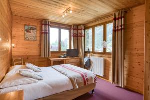 a bedroom with a bed in a wooden cabin at Epicéa Lodge Hôtel et Camping in Pralognan-la-Vanoise