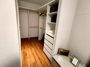 a closet with white walls and a wooden floor at LUXURY APARTMENT PISCINA Miraflores in Lima +83 photos