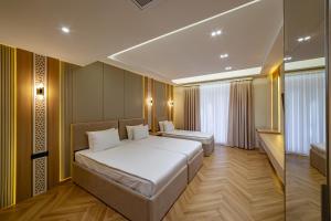 a hotel room with two beds and a window at Kamil Palace in Khiva