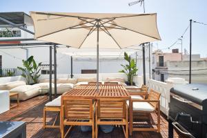 マルベーリャにあるSUNSET VILLA - Jacuzzi & Grillのテーブルと椅子と傘のあるパティオ