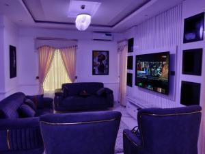 a living room with couches and a flat screen tv at Evarest Metrostay Global in Iranla