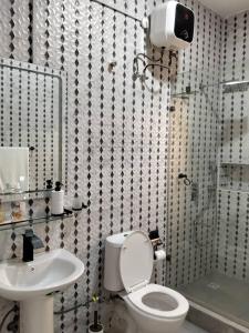 a bathroom with a toilet and a sink and a shower at Evarest Metrostay Global in Iranla