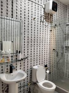 a bathroom with a toilet and a sink at Evarest Metrostay Global in Iranla +63 photos