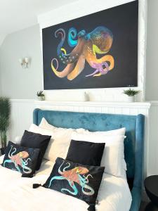 a bedroom with a bed with an octopus painting on the wall at Coastline Retreats - Stunning Sea View Apartment, Netflix in Southbourne +2 photos