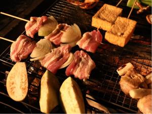 een grill met vlees en appelschijfjes erop bij Kominka Sauna & BBQ TK-tei in Ichihara