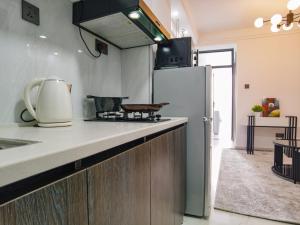 a kitchen with a stove and a refrigerator at Modern 1 BR City views Kilimani 12th floor Luxury in Nairobi +13 photos