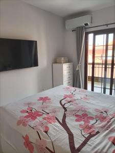 a bedroom with a bed with pink flowers on it at Costa del Silencio Balcon del mar Summer Tenerife in Arona