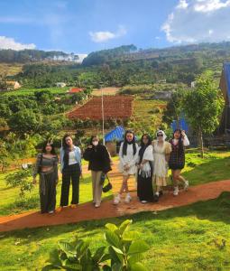 a group of women posing for a picture on a hill at Homestay Đà Lạt Xưa in Namban +54 photos