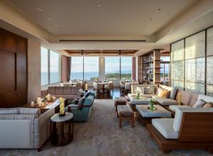 a hotel lobby with couches and tables and windows at ANA InterContinental Manza Beach Resort by IHG in Onna