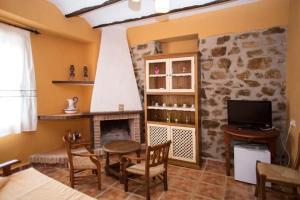 a living room with a table and a fireplace at casarural lapandera in Los Villares