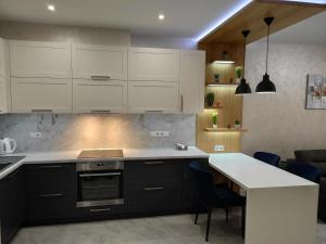 une cuisine avec des placards blancs et un îlot de cuisine dans l'établissement Люкс Апартаменти в центрі міста, à Soumy