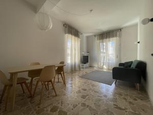 a living room with a table and chairs and a couch at The Greek House RC in Reggio Calabria
