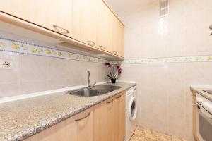 a kitchen with a sink and a washing machine at Apartamentos MARE INTERNUM III La Pineda in La Pineda +26 photos