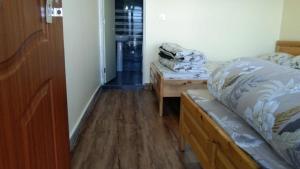 una camera da letto con un letto e un pavimento in legno di Petratos Homestay a Kalimpong