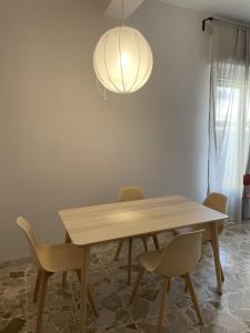 a dining room table with chairs and a light fixture at The Greek House RC in Reggio Calabria +4 photos