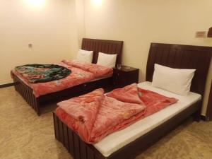 two beds sitting next to each other in a room at Hotel Green Executive in Dargai