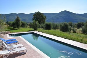 a swimming pool with two lounge chairs next to it at La Casa Nell'Oliveto Bed & Breakfast in Acquasparta