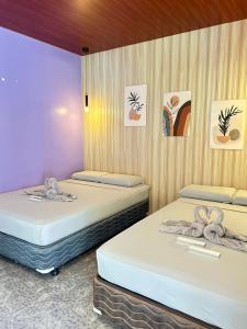 two beds sitting next to each other in a room at Baybay Hostel in Siquijor