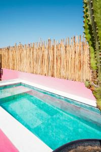 a swimming pool in front of a wooden fence at Riad Looma in Marrakesh