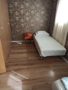 a bedroom with two beds and a wooden floor at Great House with a panoramic view in Storsæter