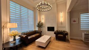 a living room with a leather couch and a table at Vancouver Burnaby Villa 36 in Burnaby