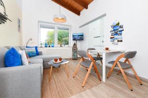 a living room with a couch and a table and chairs at Ferienwohnung Happynest in Bensersiel