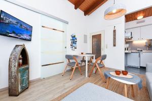 a living room with a table and chairs and a kitchen at Ferienwohnung Happynest in Bensersiel