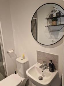 Un baño con un inodoro blanco y un espejo. en Dylchrikie House, en Barnstaple 5 fotos más