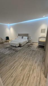 a bedroom with a white bed and a wooden floor at مبيت و إفطار - Bed & Breakfast in Hatta +4 photos