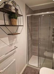 Un baño con ducha con puerta de cristal. en Dylchrikie House, en Barnstaple