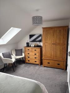 Un dormitorio con una cama y una cómoda y una ventana. en Dylchrikie House, en Barnstaple