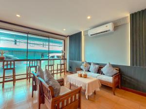 a living room with a couch and a table at ClayHouse SAMUI Boutique Hotel in Koh Samui