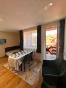 Una sala de estar con una mesa y una cama. en Private large apartment in Iglika 2 for 4 people, en Borovets