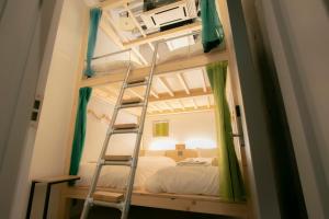 a bunk bed with a ladder in a bedroom at Theatel Sapporo in Sapporo