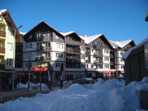 Un gran edificio con nieve delante. en Private large apartment in Iglika 2 for 4 people, en Borovets