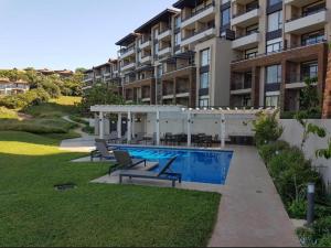 a swimming pool in front of a building at Zimbali Hotel Unit 422 Suites in Ballito