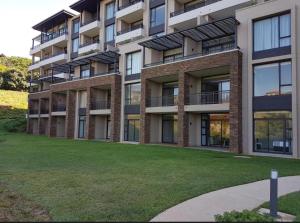 an apartment building with a lawn in front of it at Zimbali Hotel Unit 422 Suites in Ballito