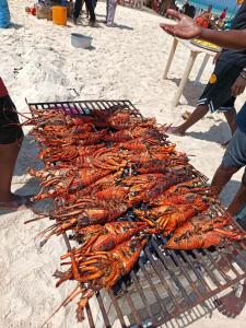 a bunch of lobsters on a grill on the beach at DOGO E ILARIA Bed & Breakfast in Nungwi