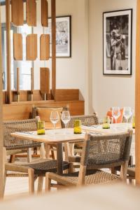 a dining room with tables and chairs with wine glasses at Setclub Hôtel & Spa Aix-en-Provence in Aix-en-Provence