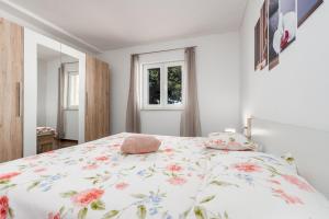 a bedroom with a bed with a floral bedspread at Holiday House Laetitia with pool in Banjevci +64 photos