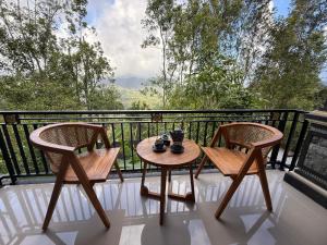 a balcony with two chairs and a table on it at D'Labake Guest House in Sidemen
