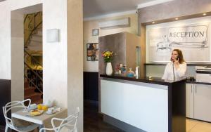 a woman talking on a cell phone in a kitchen at Hotel Delizia in Milan