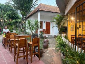 un restaurant avec des tables et des chaises en bois devant un bâtiment dans l'établissement Cao Nguyên Bungalow, à Duong Dong