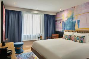 a hotel room with a large bed and a desk at NYX Hotel Edinburgh in Edinburgh