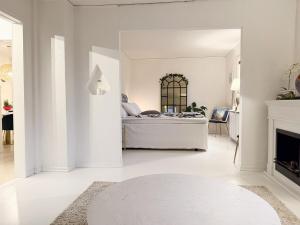 un soggiorno bianco con letto e camino di Bright 4BR Hilltop Villa Close to Gothenburg City a Mölnlycke