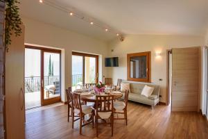 a dining room with a table and chairs and a couch at Maison Balù Villa in Torri del Benaco