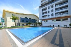 a large swimming pool in front of a building at Monarchy Riverside Da Nang - Modern Stay & Pool in Danang