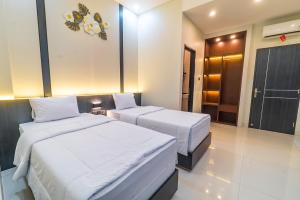 two beds in a hotel room with a room at Gomini Stay in Cebongan